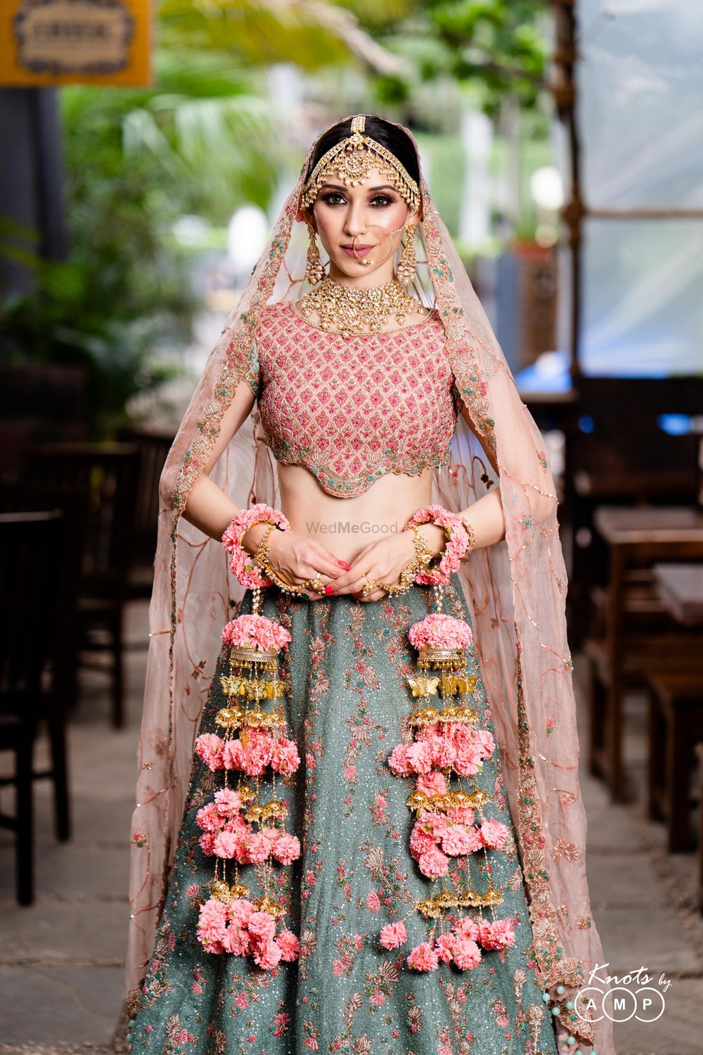 Photo of A beautiful bride in a stunning outfit and off-beat floral kaleere and gold jewellery.