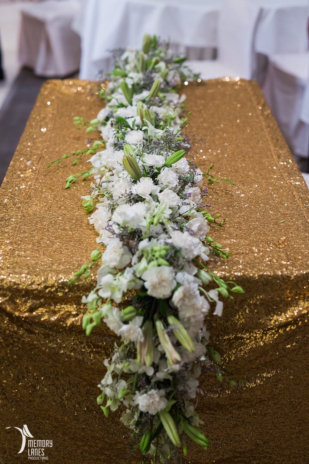 Photo of Gold Glitter Table with Floral Runner Decor