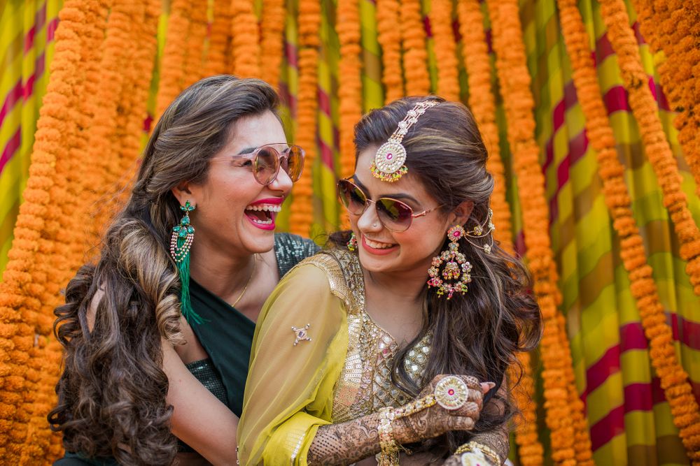 Photo of A bride wearing pretty gota jewellery with her sister on her mehndi ceremony