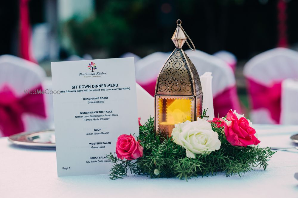 Photo of White Table with Floral Centerpiece and Lanterns