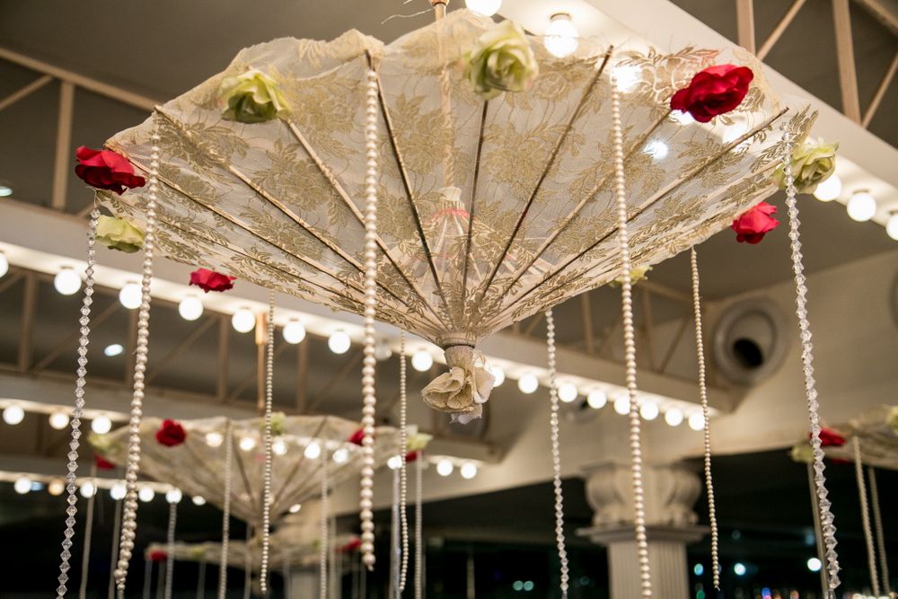Photo of White Hanging Upside Down Umbrellas with Floral Decor