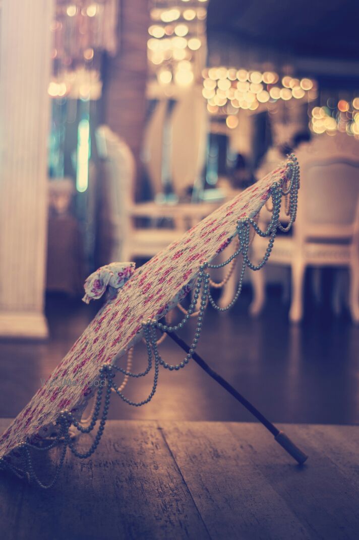 Photo of White and Pink Floral Umbrellas with Bead Strings