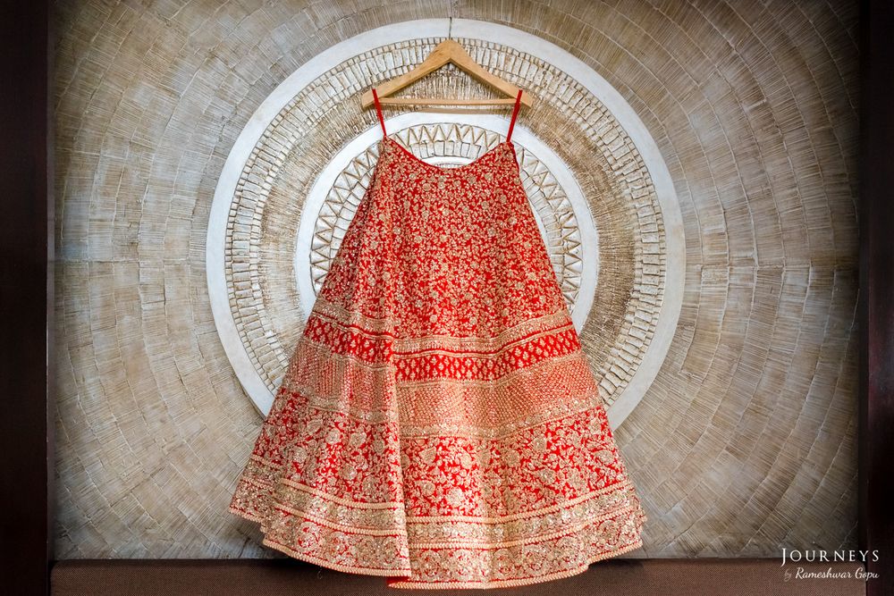 Photo of Bright Red and Gold Heavy Lehenga on a Hanger