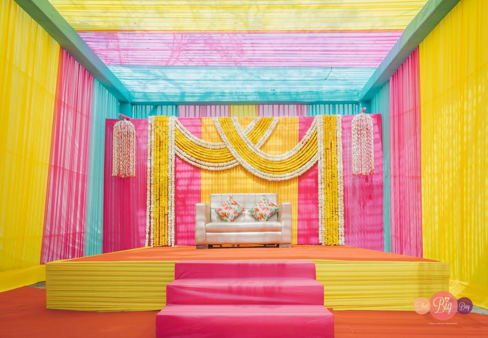 Photo of funky mehendi stage backdrop with loads of colours