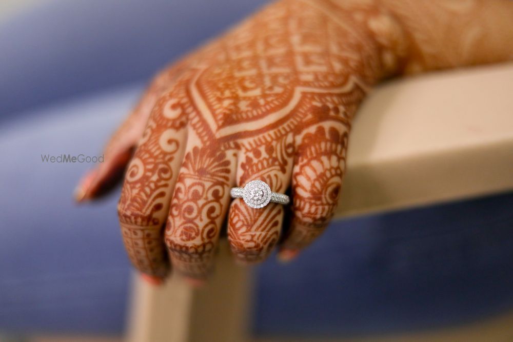 Photo of bridal hands with mehendi and engagement ring shot