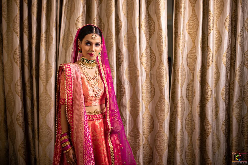 Photo of bride in orange and pink banarasi lehenga on her wedding