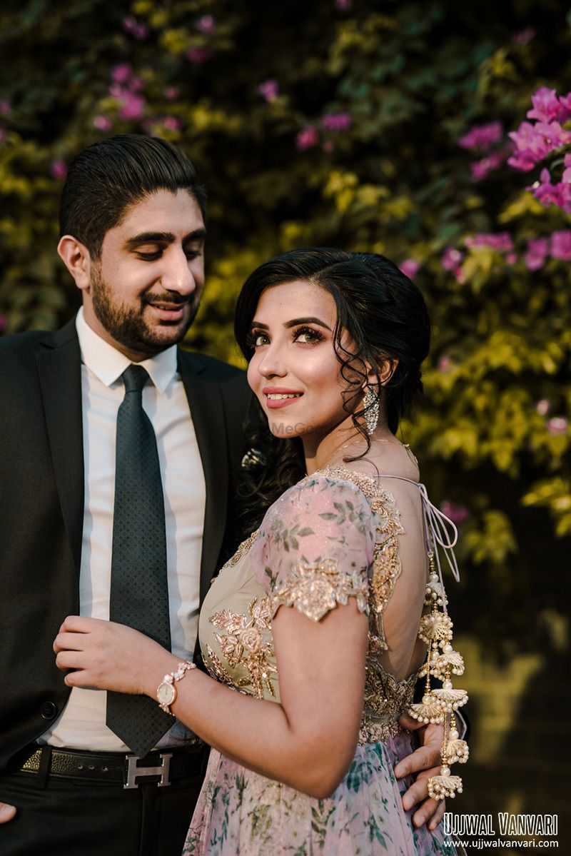 Photo of A couple poses together in light, breezy outfits