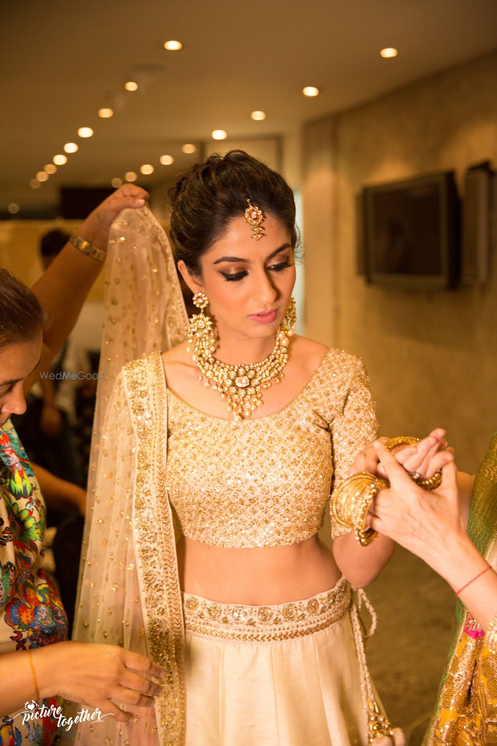 Photo of bridal shot in gold lehenga getting ready