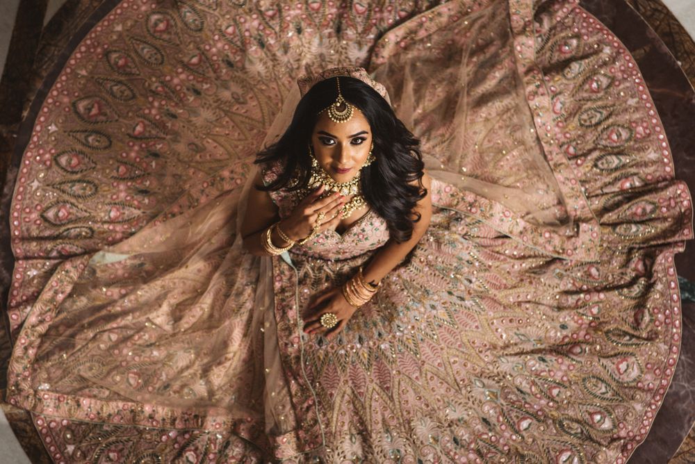 Photo of bride with open hair sitting with flared lehenga