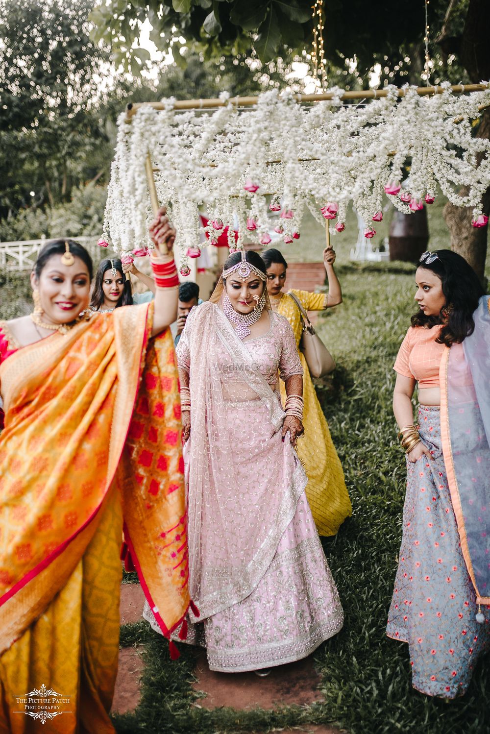 Photo of A bride under a phoolon ki chaadar carried by her sisters