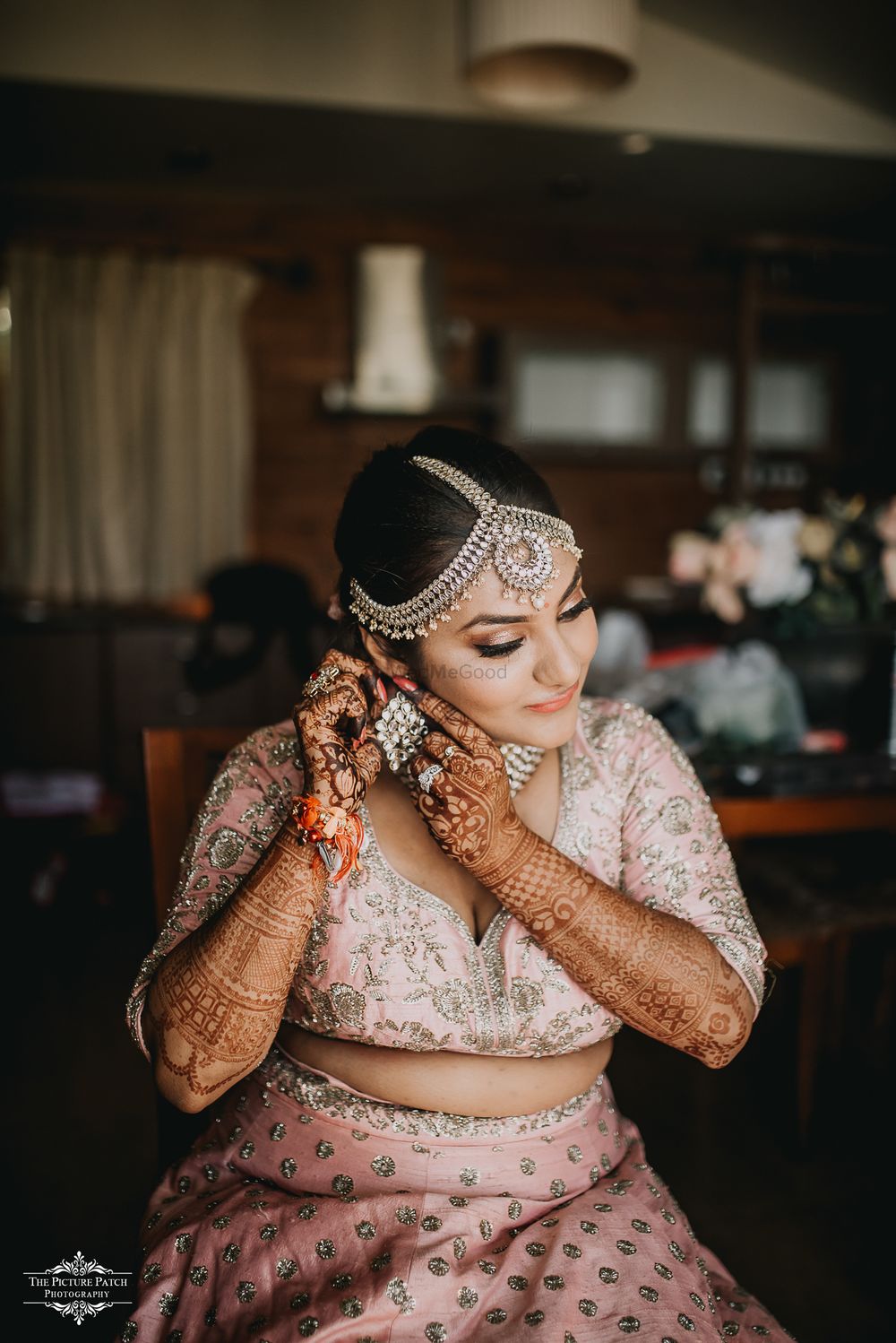 Photo of A bride in a pink lehenga getting ready for her wedding