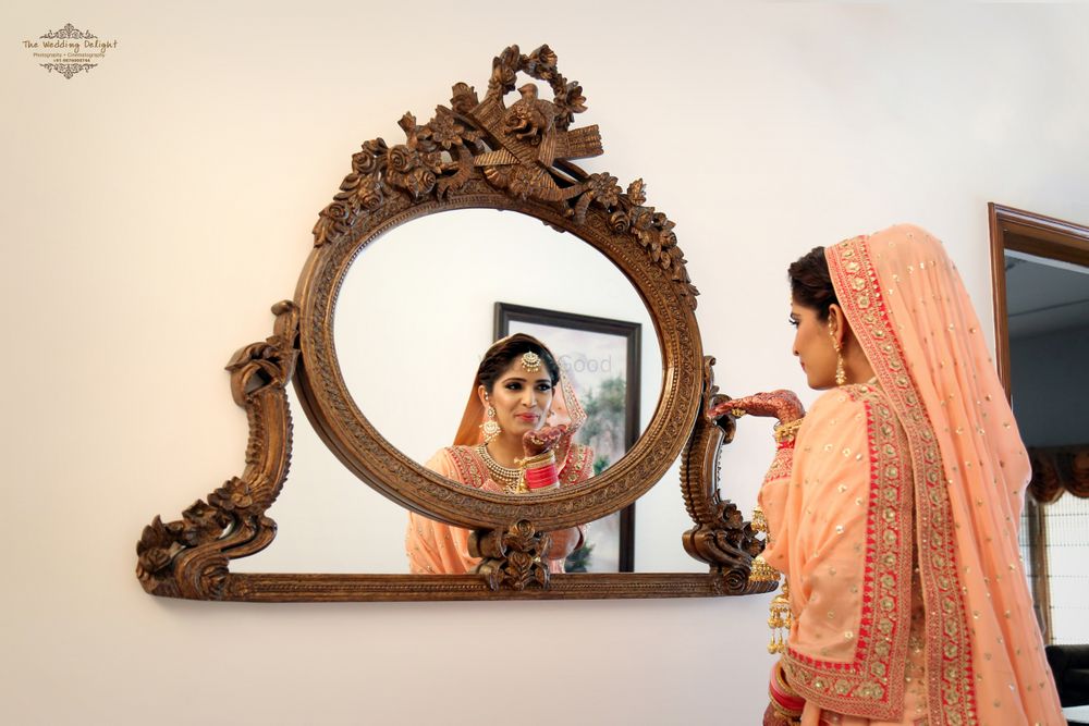Photo of Peach Bride Looking Through The Mirror Shot