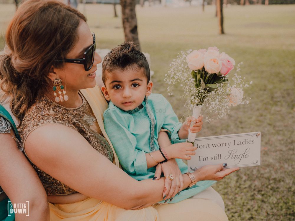 Photo of kid holding a cute sign at the wedding