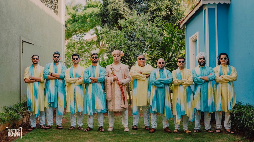 Photo of colour coordinated groomsmen with the groom
