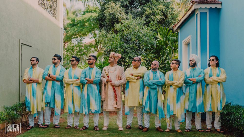 Photo of colour coordinated groomsmen with groom photo