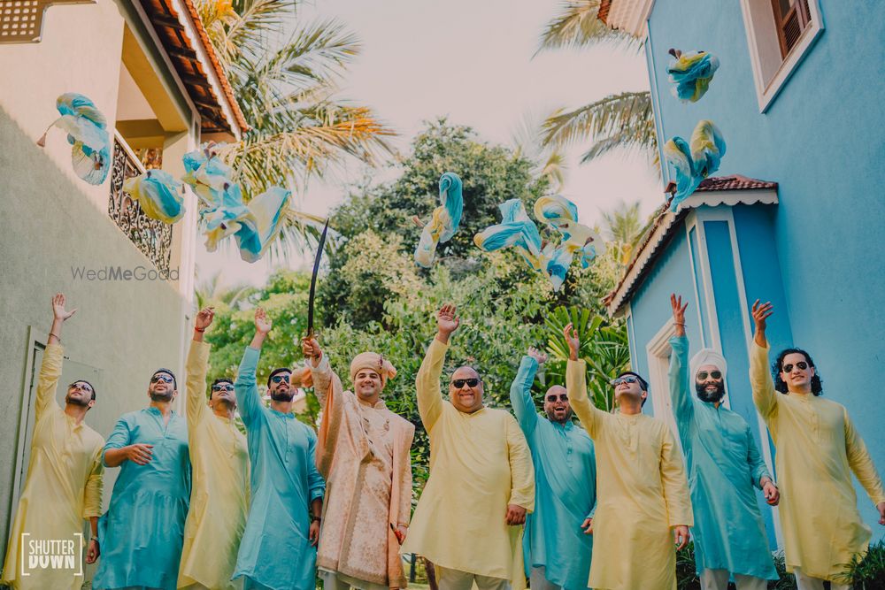 Photo of groom and groomsmen throwing safa shot