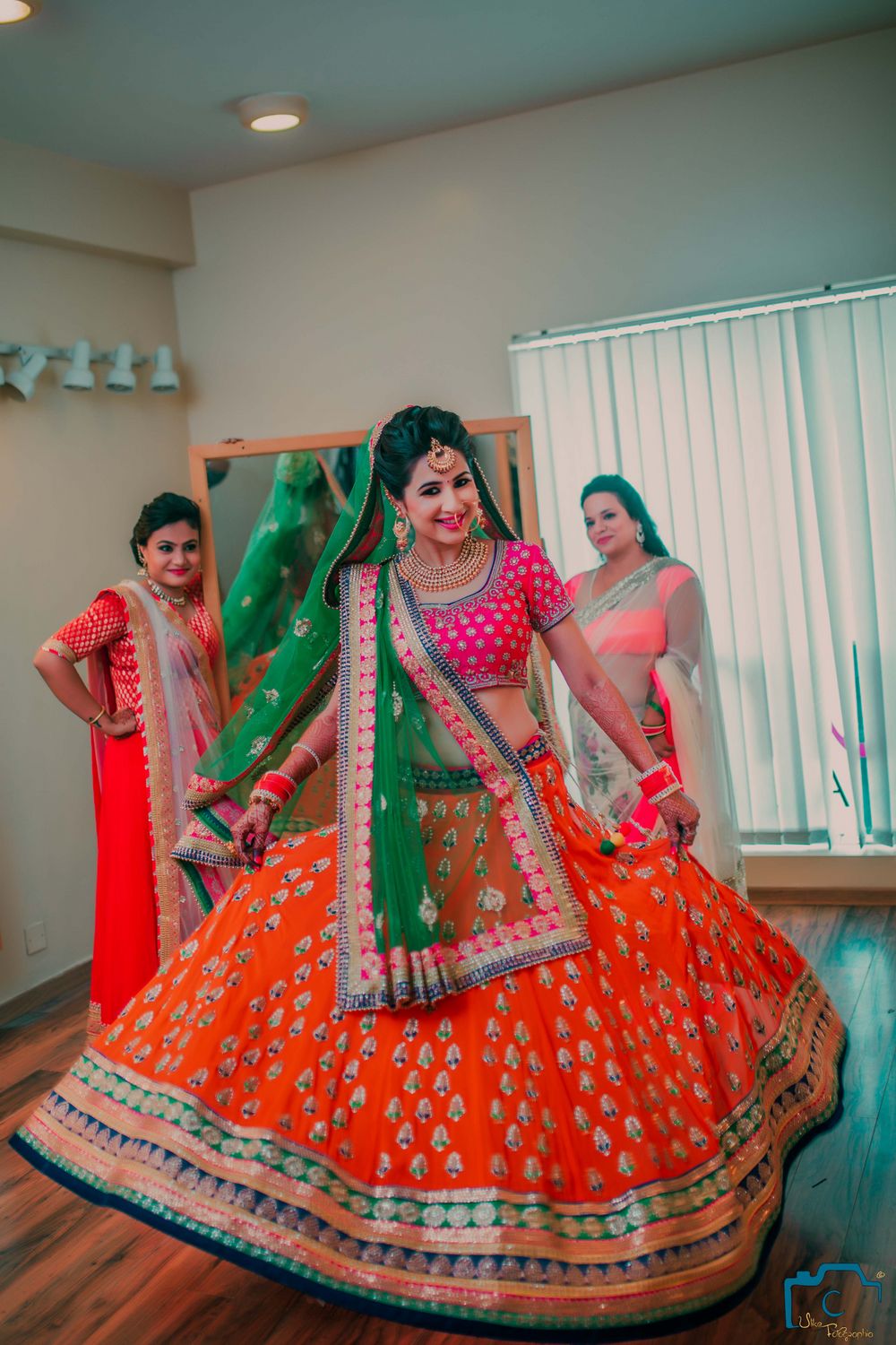 Photo of Twirling Bride in orange lehenga
