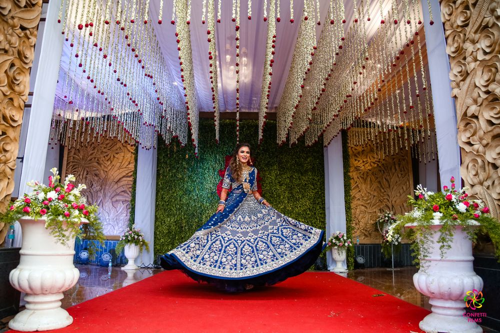 Photo of bride twirling in a royal blue lehenga
