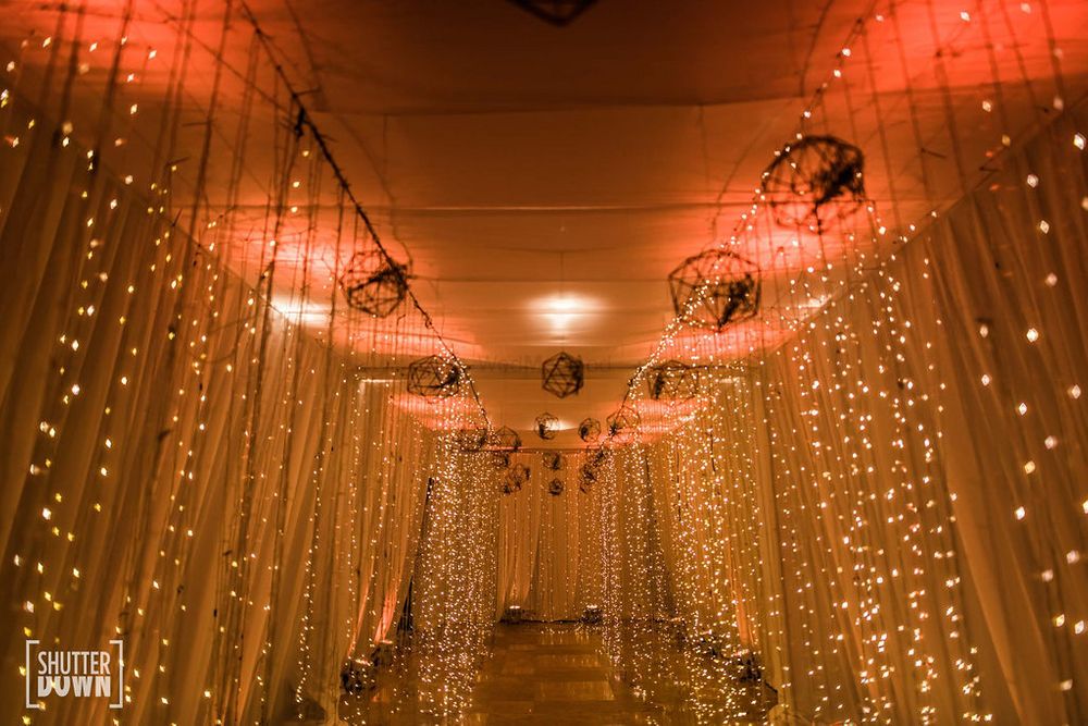 Photo of cocktail or sangeet entrance decor idea with fairy lights