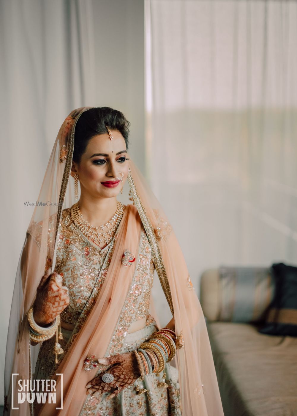 Photo of bride in light peach and mint lehenga