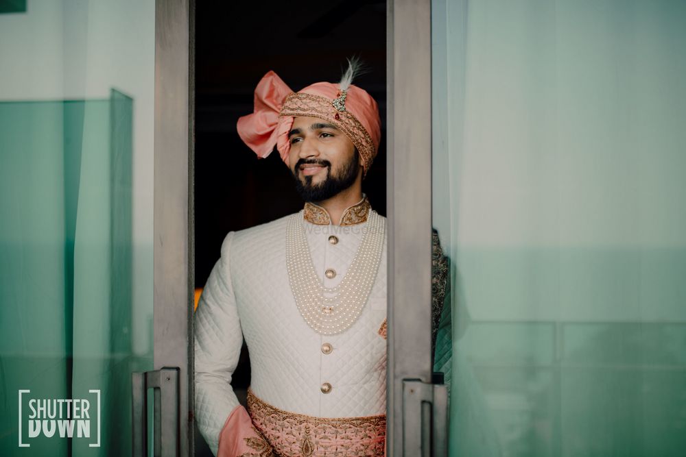 Photo of unique groom look with contrasting safa and waistbelt