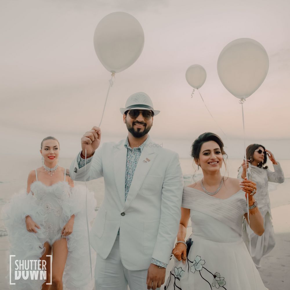 Photo of beach wedding idea with couple entry holding balloons