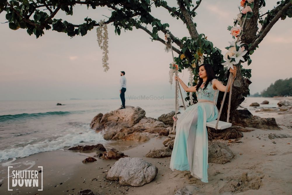 Photo of beach pre wedding or honeymoon shot with bride on swing