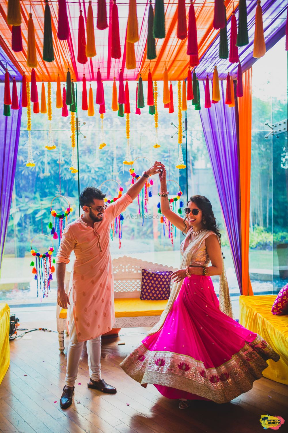 Photo of A bride in pink dancing with her to-be-husband on their mehendi ceremony