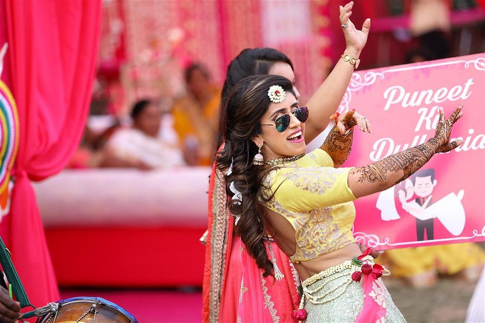 Photo of dancing bride on her mehendi in yellow blouse