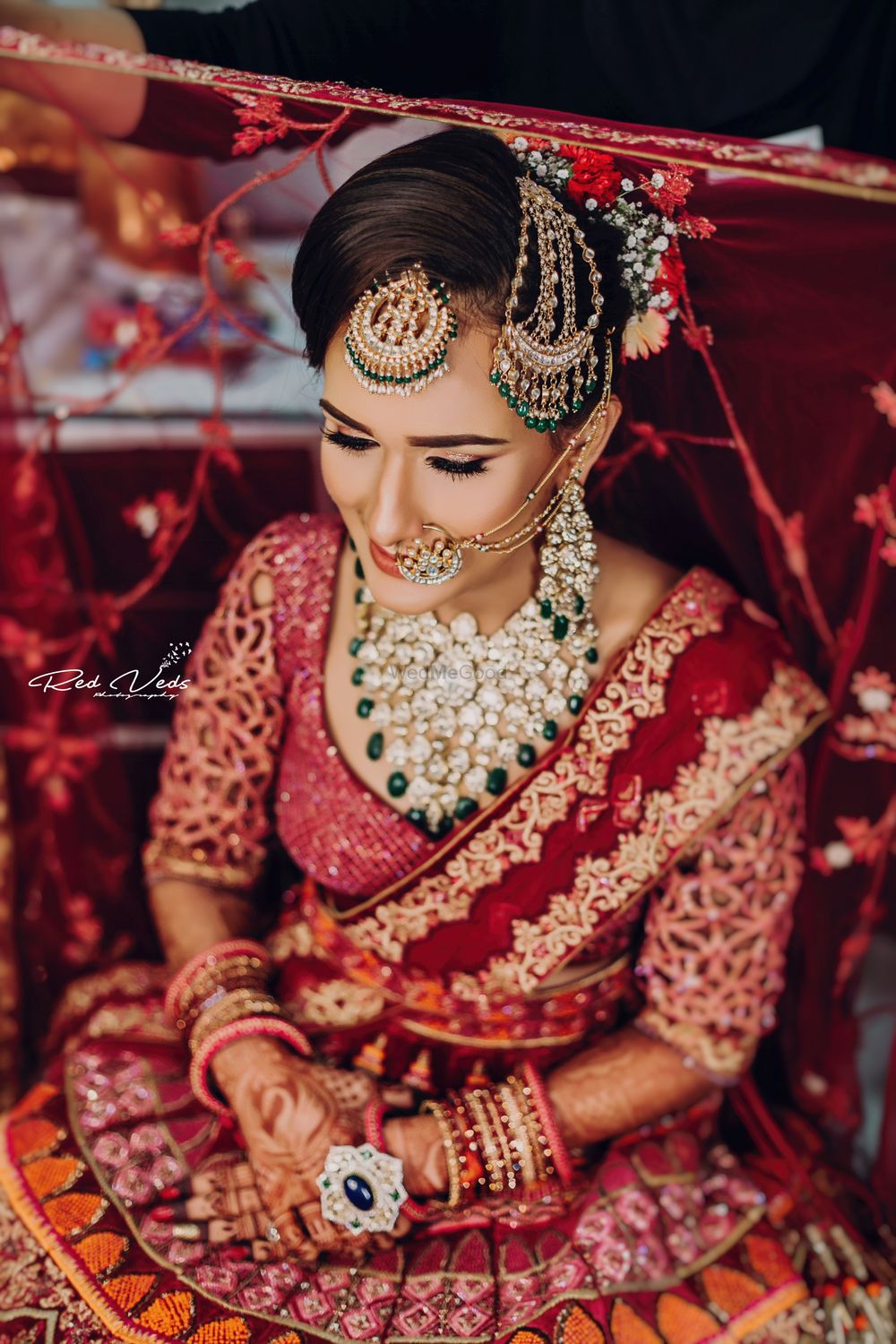 Photo of bride wearing contrasting jewellery and maangtikka and jhoomar