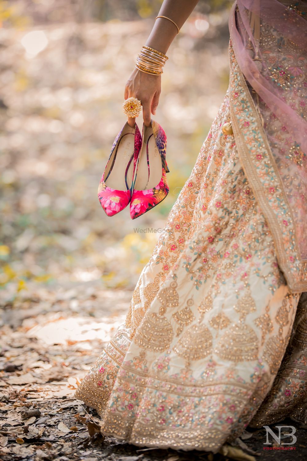 Photo of bride holding her hot pink bridal shoes