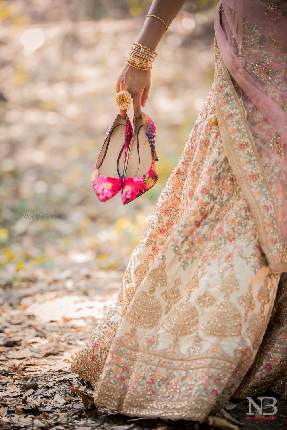 Photo of bride holding her hot pink bridal shoes