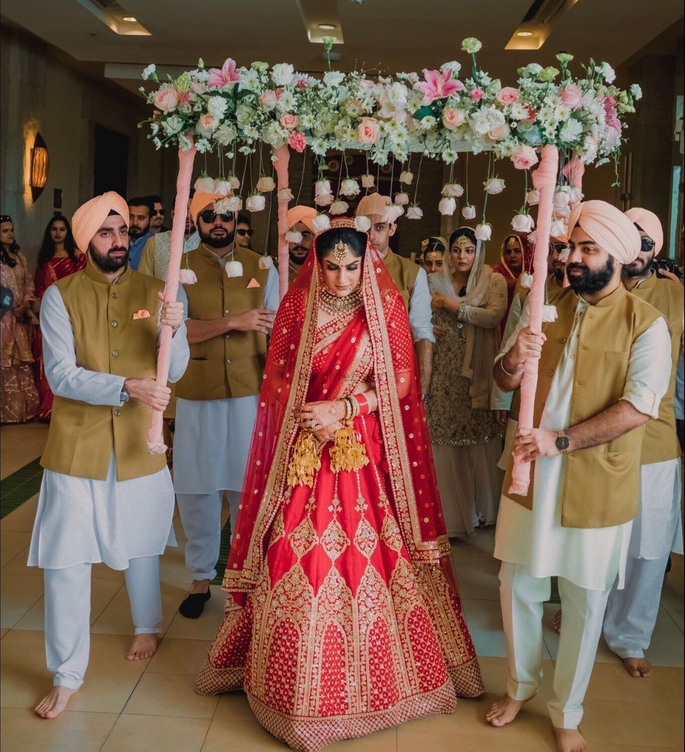 Photo of bridal entry portrait in red lehenga under phoolon ki chadar