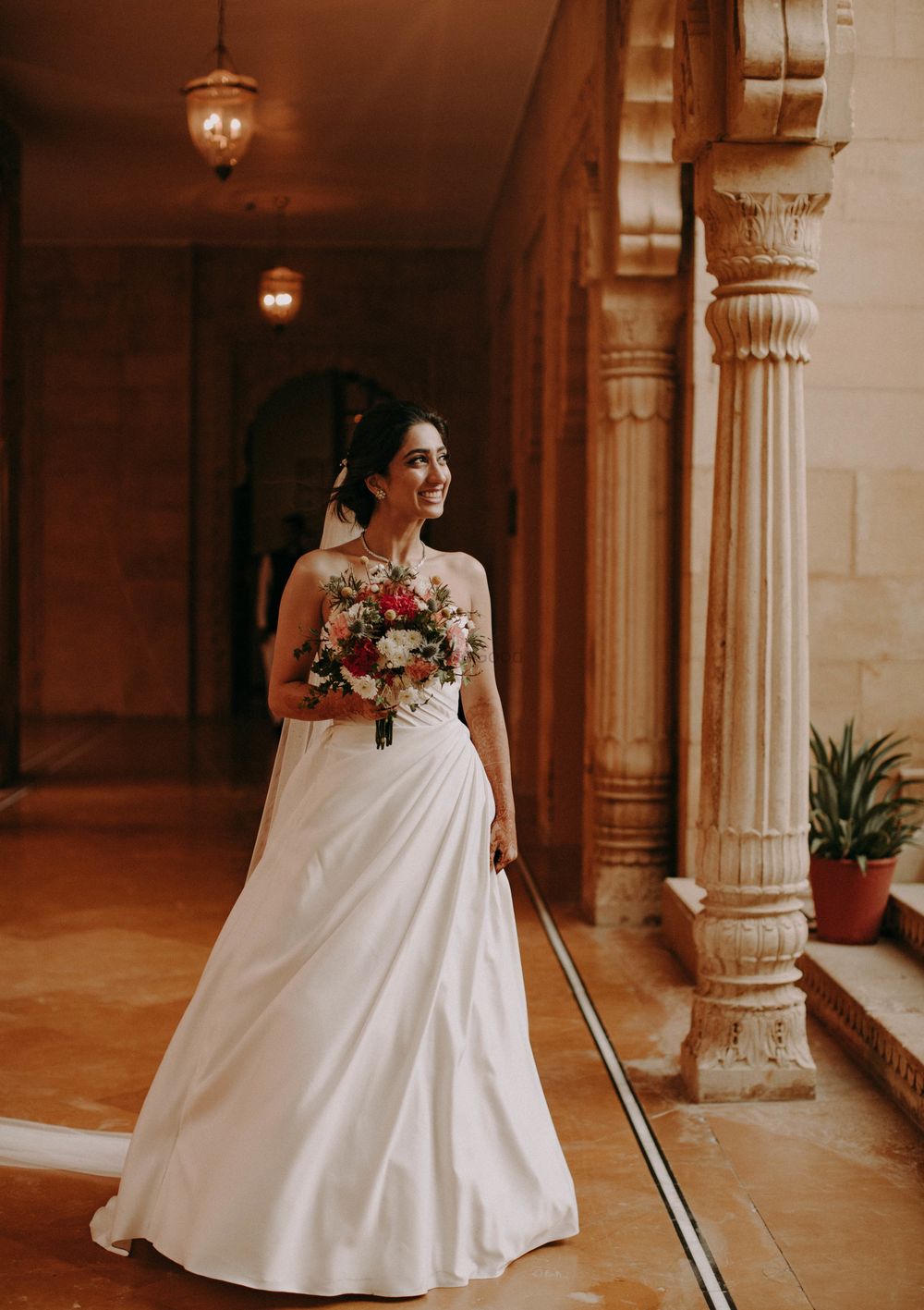 Photo of christian bride in white gown and colourful bouquet