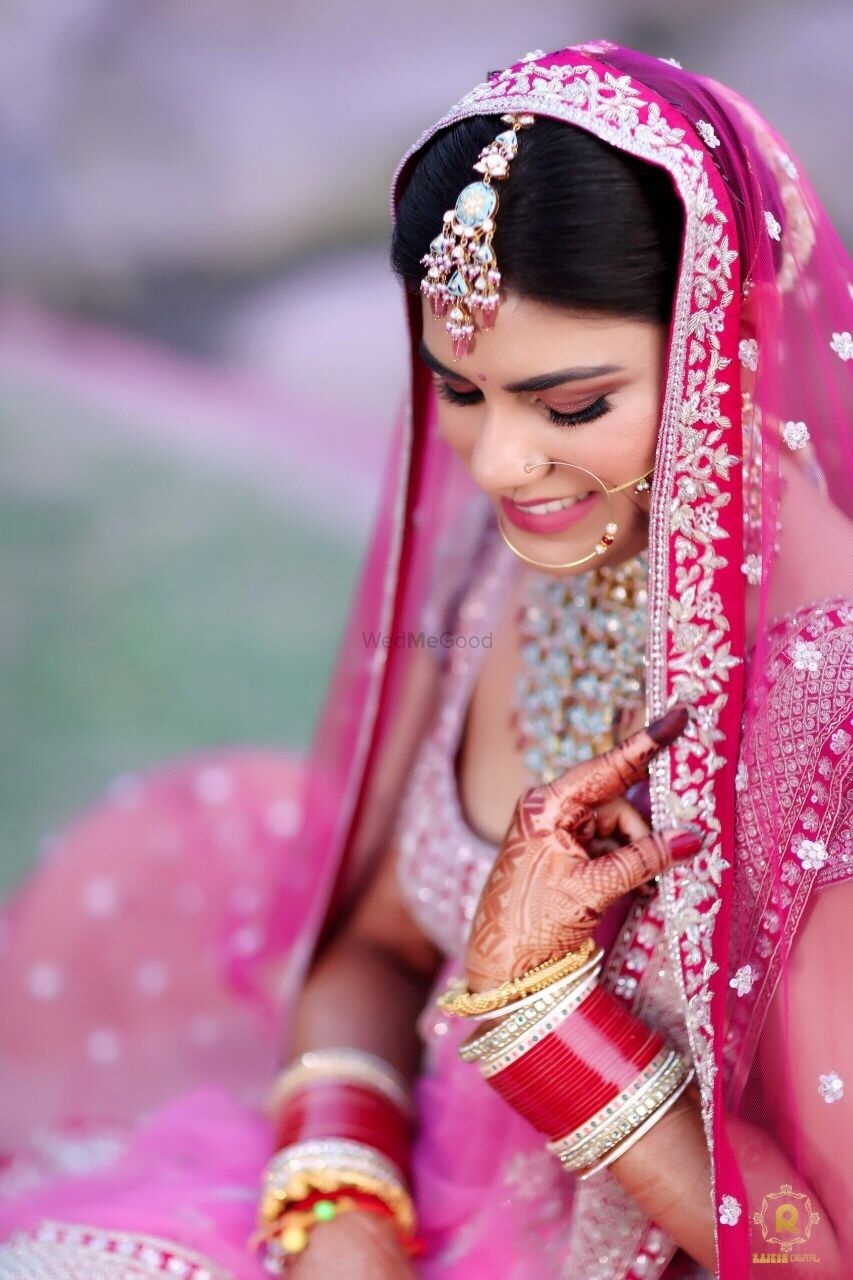 Photo of bride in bright pink lehenga