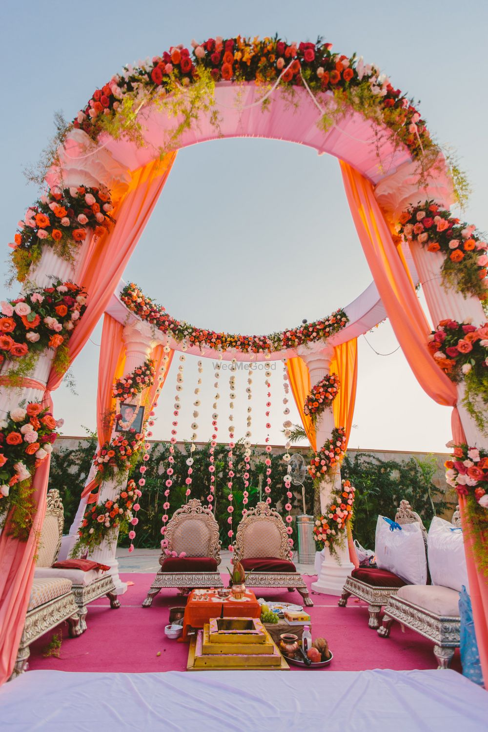 Photo of Light pink and red mandap with flowers