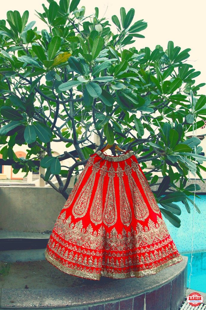 Photo of Red and Gold Heavy Lehenga on a Hanger