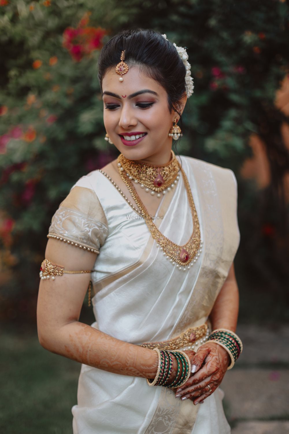 Photo of Malayali bride in gold jewellery and white saree.