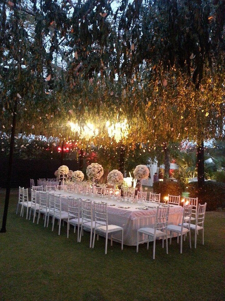 Photo of White Table Decor with Hanging Lights and Floral Decor