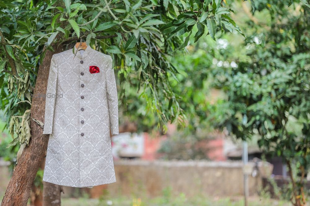 Photo of White Sherwani with Red Pocket Square on a Hanger