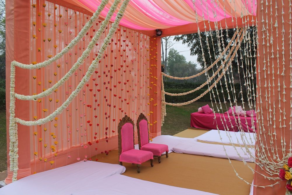Photo of peach and bright pink mandap decor