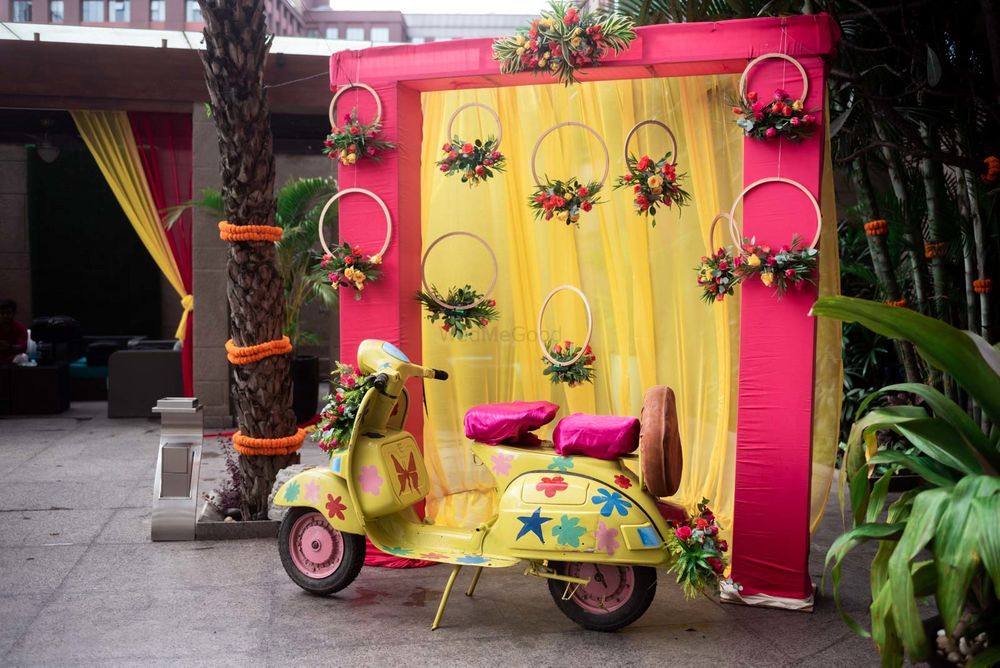 Photo of Pink and yellow photobooth decor with a scooter