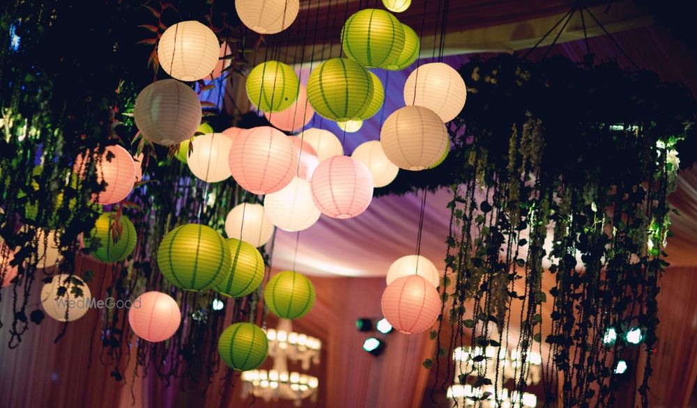 Photo of Hanging lanterns green apply and blush pink for indoor banquet decor