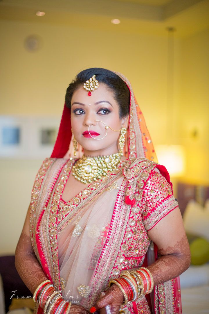 Photo of Pastel Pink and Red Lehenga with Gold Jewelry