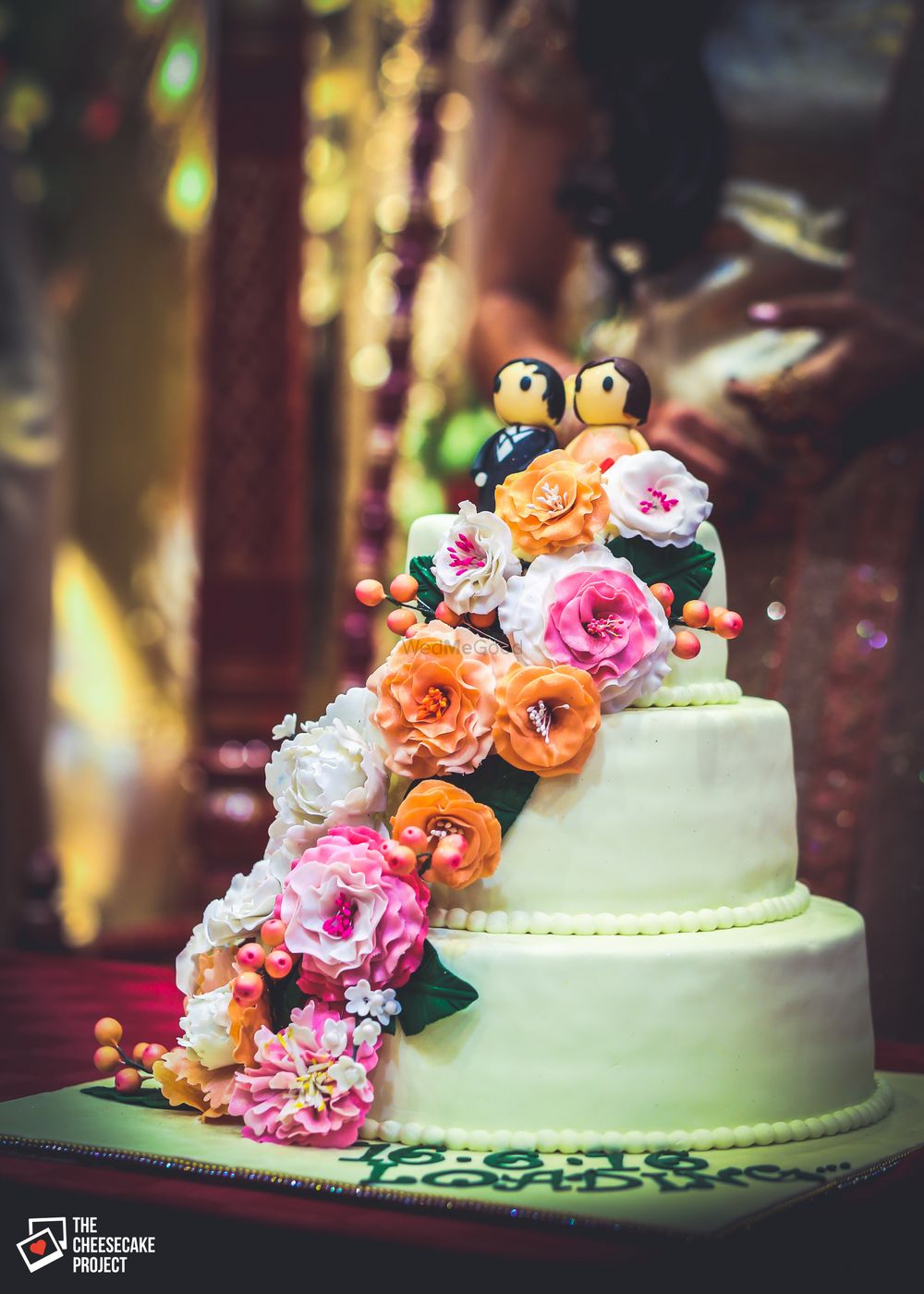 Photo of 3 Tier Wedding Cake with Couple Models and Floral Decor