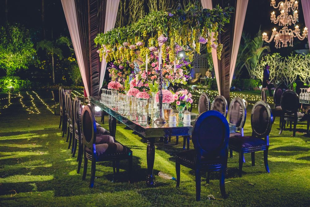 Photo of Table setting decor with pink flowers, blue chairs and some greens