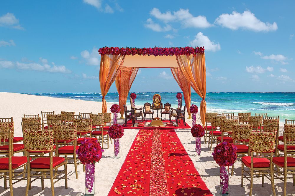 Photo of A gorgeous mandap set up by the sea in hues of gold and red