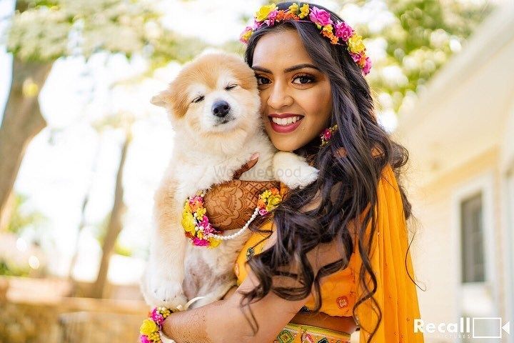Photo of A bride posing with her dog on her mehndi ceremony