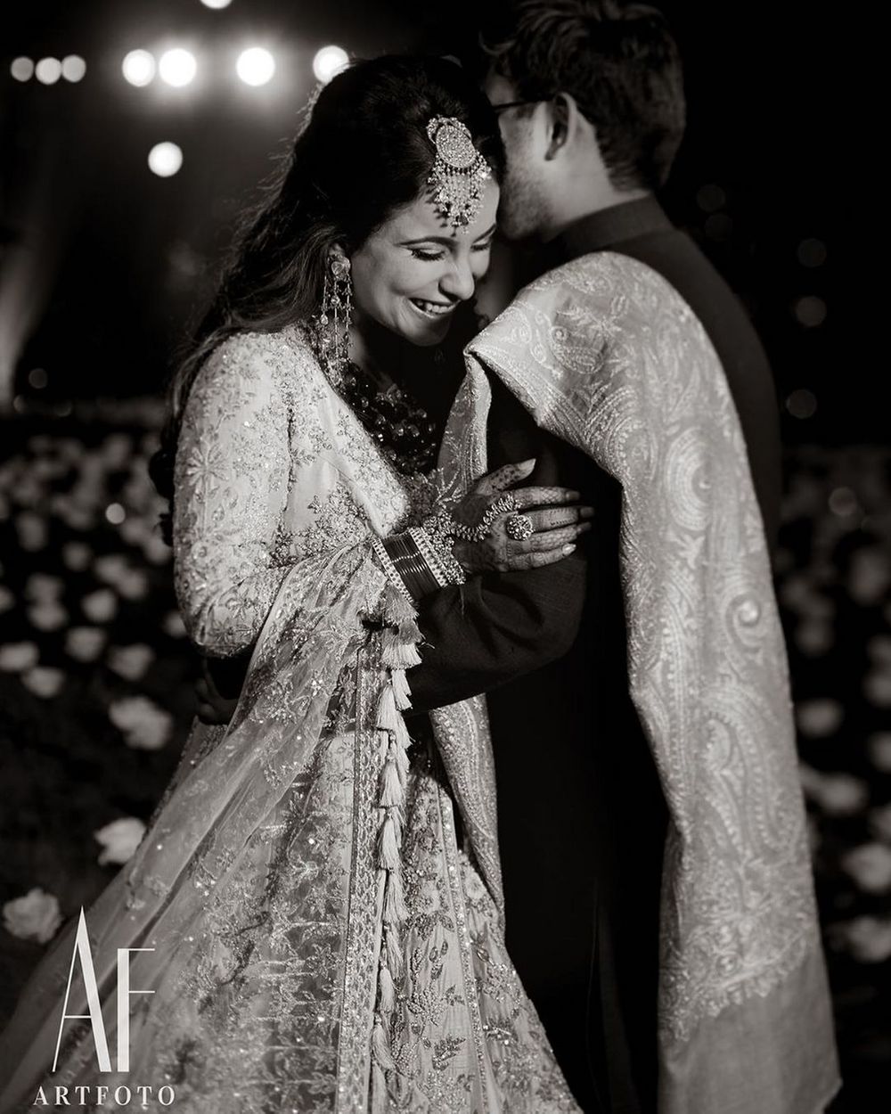 Photo of A candid shot of a bride and groom hugging each other.