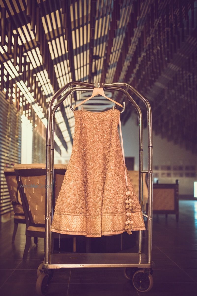 Photo of Dull Gold Bridal Lehenga with Latkans on a Hanger